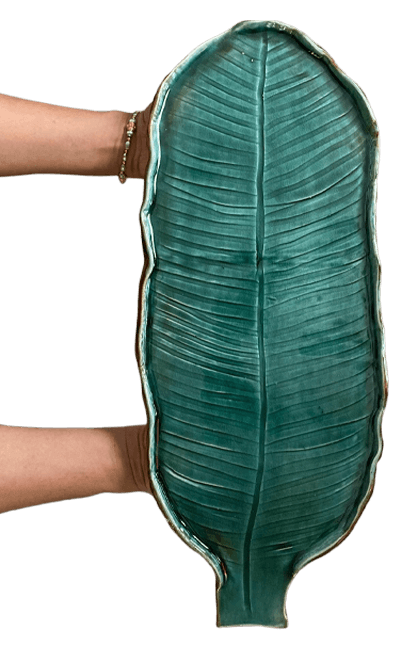 Hand-shaped stoneware banana leaf platter held in two hands