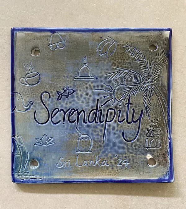 Square ceramic wall plaque with 'Serendipity' and 'Sri Lanka' inscriptions, featuring cobalt and gray glazes.