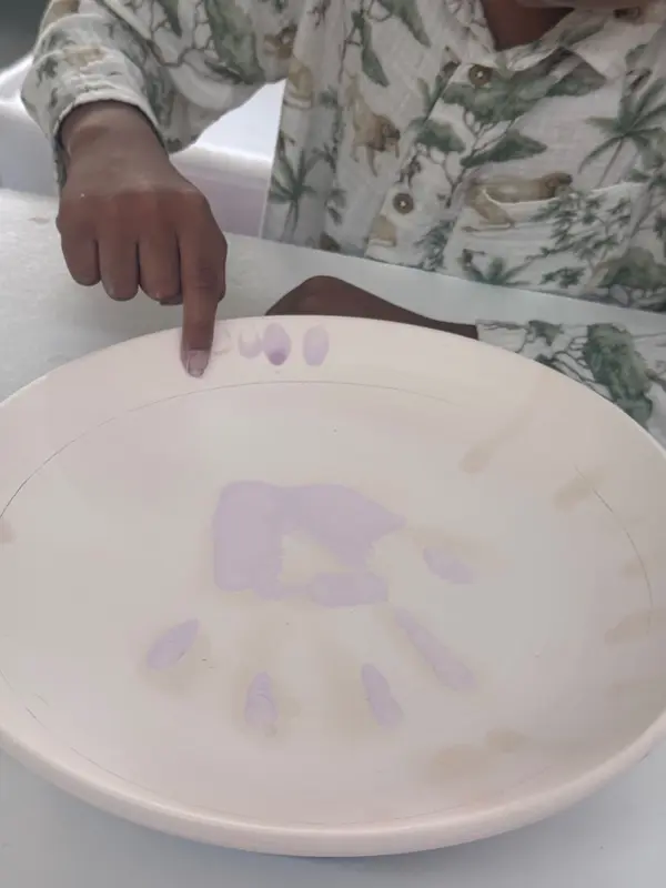 Large white ceramic platter with a lilac child's handprint in the center and fingerprints along the rim.