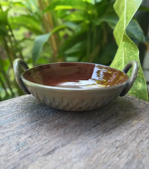 Small ceramic thaachiya bowl with handles, glossy brown interior and a textured matte grey exterior.