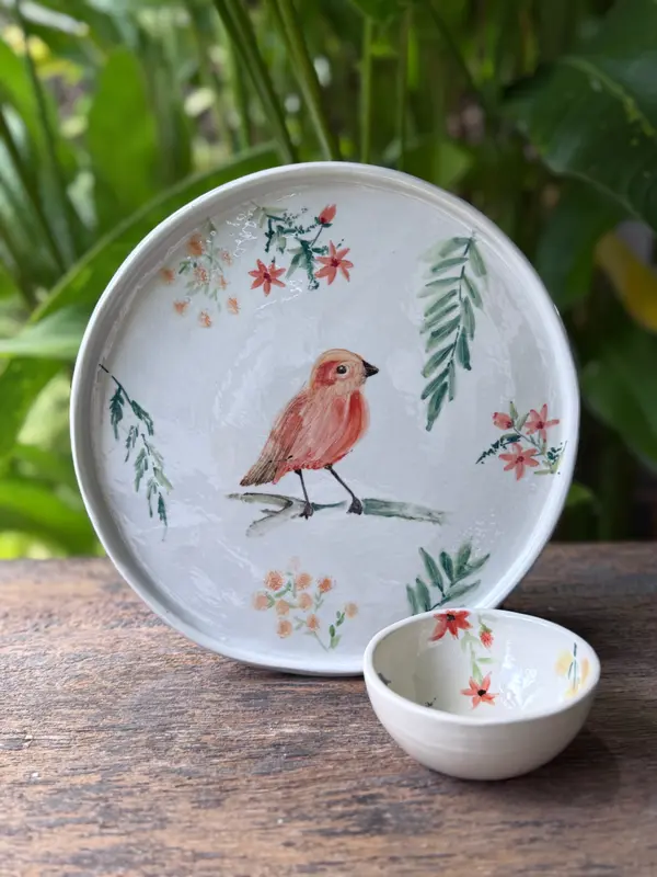 White ceramic plate and small bowl featuring a hand-painted bird on a branch and delicate orange floral motifs.