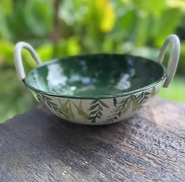 Hand-painted ceramic thaachiya bowl with twin handles, dark green interior and leafy vine exterior.