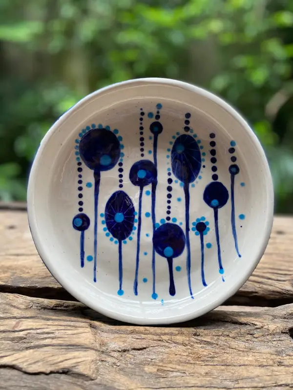 White ceramic bowl with hand-painted abstract cobalt and light blue floral patterns and dots.