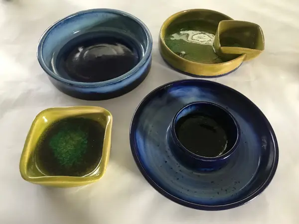 Ceramic bowls and chip-and-dip plates in cobalt blue and moss green with thick pooled glazes.