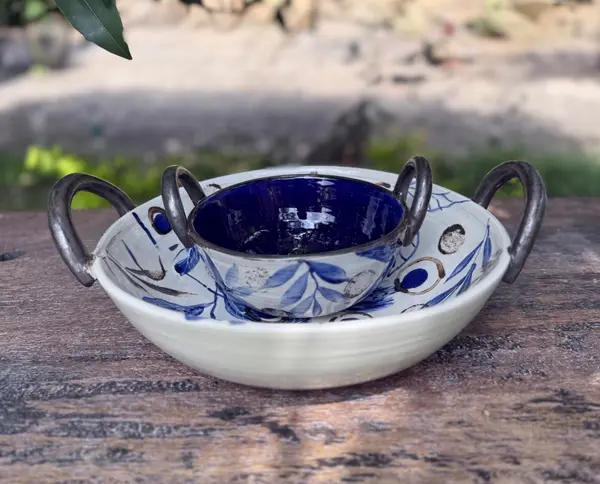 Blue and white floral ceramic serving bowl set with a deep cobalt interior and metallic-toned handles.